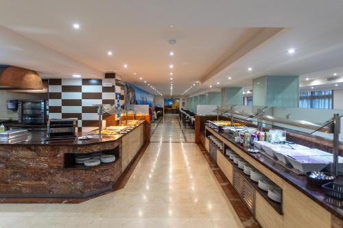 a large kitchen with a long long counter in a restaurant at Seramar Hotel Luna Park Adults Only in El Arenal