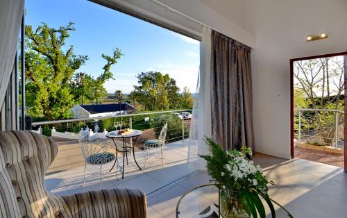 a room with a balcony with a table and chairs at Val Du Charron Wine & Leisure Estate in Wellington