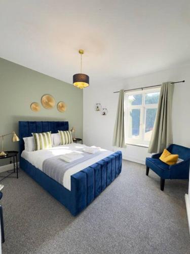 ein Schlafzimmer mit einem blauen Bett und einem blauen Stuhl in der Unterkunft RNM - Business Contractors Ready! 3 Bedrooms, Efficient Savings! Entire House,Smart Tv, 2 Lounges, Dining Area, Private Gated Parking, Easy Access, Close to M5, Train Station, Bus Routes, Kitchen and Washroom plus amenities included! in Quinton