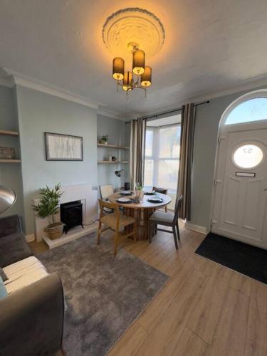 ein Wohnzimmer mit Tisch und ein Esszimmer in der Unterkunft RNM - Business Contractors Ready! 3 Bedrooms, Efficient Savings! Entire House,Smart Tv, 2 Lounges, Dining Area, Private Gated Parking, Easy Access, Close to M5, Train Station, Bus Routes, Kitchen and Washroom plus amenities included! in Quinton