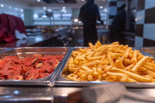 a buffet of food with french fries and sauce at Seramar Hotel Luna Park Adults Only in El Arenal