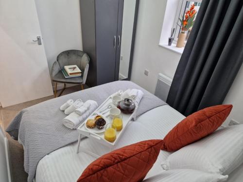 a tray of food sitting on top of a bed at Comfortable City Haven flat in Watford