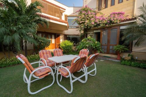 a table and four chairs in front of a house at Elevé Villa in Karachi