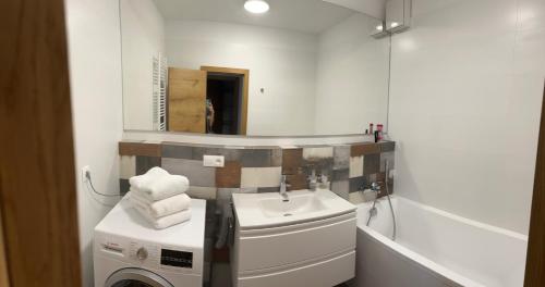 a bathroom with a sink and a washing machine at Greenbay Golf Apartments in Trenčín