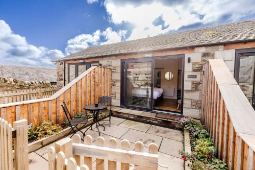 a small patio with a wooden fence and a table at The Star Inn - Harbottle - Near Rothbury - Northumberland in Morpeth