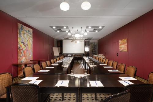 a long table in a room with red walls and chairs at Parkhotel Hitzacker in Hitzacker