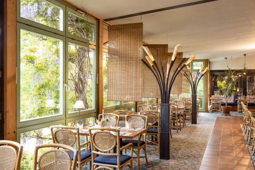 a restaurant with tables and chairs and windows at Parkhotel Hitzacker in Hitzacker