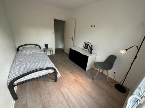 une chambre avec un lit, un bureau et une chaise dans l'établissement Maison 4 chambres avec jardin, à Mont-de-Marsan