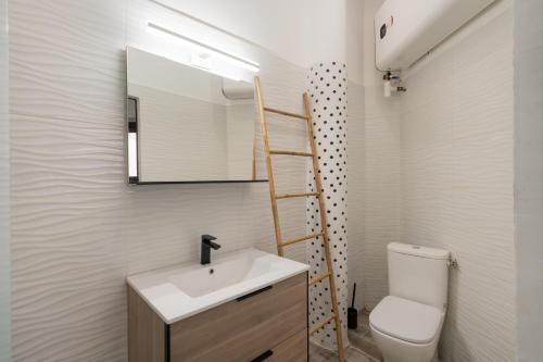 une salle de bain avec un lavabo, des toilettes et un miroir dans l'établissement Cosy studio magnifique vue mer, à Marseille