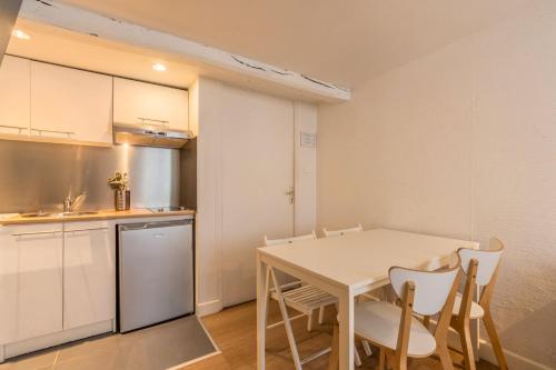 une cuisine et une salle à manger avec une table et des chaises dans l'établissement Appartement dans un quartier vivant du Vieux-Lille, à Lille