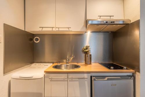 une petite cuisine avec un évier et une cuisinière dans l'établissement Appartement dans un quartier vivant du Vieux-Lille, à Lille