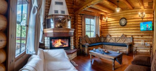 a living room with a fireplace in a log cabin at Mountain Escape Chalet in Karpenision