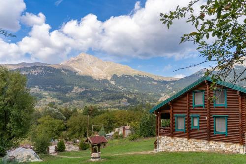 a log cabin with a mountain in the background at Mountain Escape Chalet in Karpenision