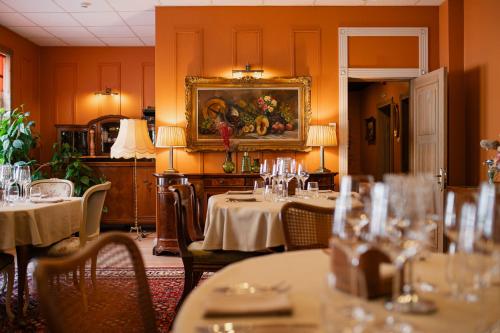 a restaurant with tables and chairs and a painting on the wall at Boutique Hotel Virkas muiža in Kuldīga