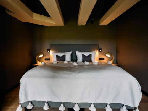 a bedroom with a large bed with white sheets and pillows at Sturmhaube Sylt in Kampen
