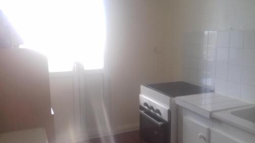 une cuisine avec une cuisinière et une fenêtre. dans l'établissement Daxy91, à Ris-Orangis