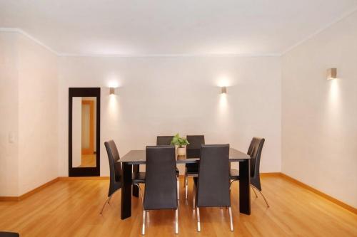 a dining room with a black table and chairs at MyOasis I - Algarve in Olhão
