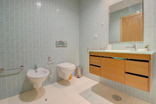 a bathroom with a toilet and a sink and a mirror at MyOasis II - Algarve in Olhão