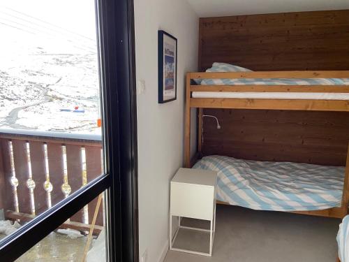 a bedroom with two bunk beds and a balcony at AltiPAM Lodge Val Thorens in Val Thorens