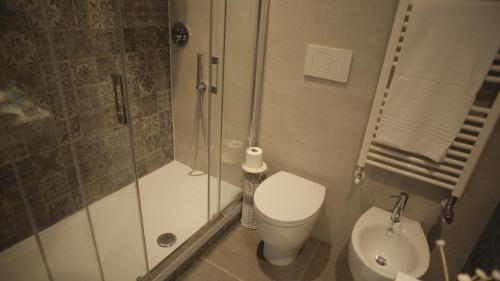 a bathroom with a shower and a toilet and a sink at Ponterosso Suite in Trieste