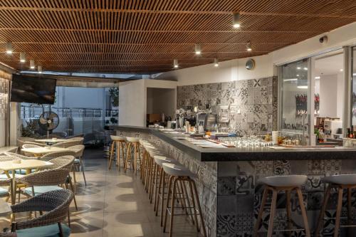 a restaurant with a bar with chairs and tables at Park Beach Hotel in Limassol