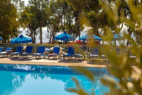 a group of chairs and umbrellas next to a swimming pool at Park Beach Hotel in Limassol