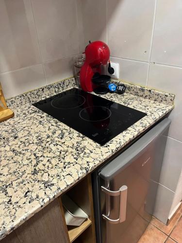 a kitchen counter with a red appliance on it at La Casita Roja Del Arcoíris in Riópar
