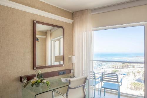 a room with a mirror and a table and chairs at Renaissance Tel Aviv Hotel in Tel Aviv