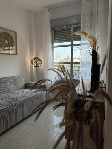 a living room with a couch and a large window at Apartamentos Modern Homes in Chiclana de la Frontera