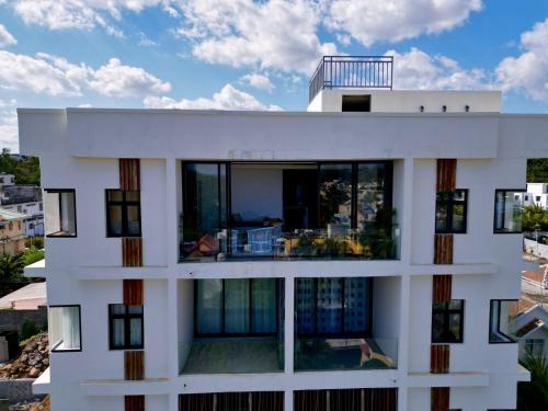 a large white building with glass windows at Cozy Seaview Penthouse in Flic-en-Flac