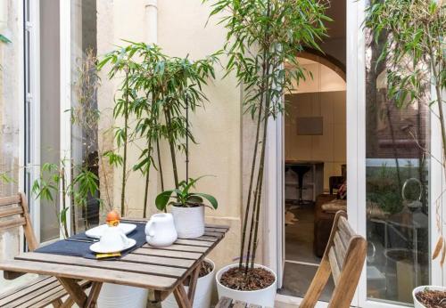 a wooden table on a balcony with potted plants at Historical Apartment Congress Center in Lisbon