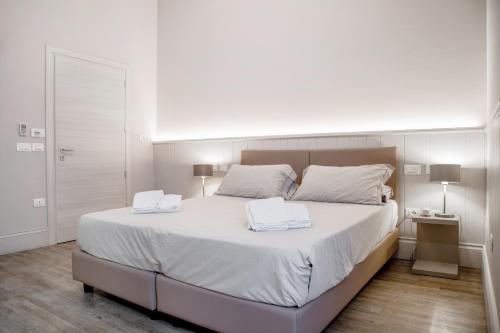 a bedroom with a large bed with two towels on it at Hotel De La Ville depandance di Hotel Augustus in Fano