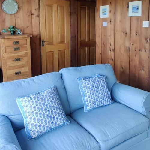 a blue couch with two pillows on top of it at Small cottage in Camp, Kerry on the Dingle Way in Camp