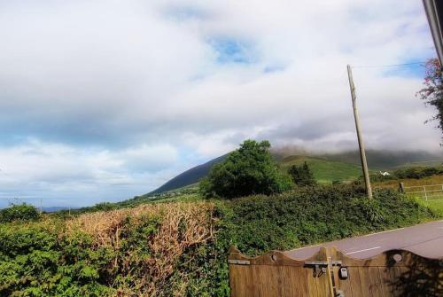 a fence in front of a hill with a mountain at Small cottage in Camp, Kerry on the Dingle Way in Camp