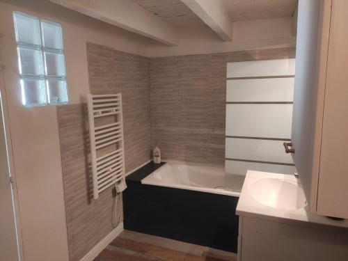 une salle de bain avec une baignoire et un lavabo dans l'établissement Les jardins de Shambhala, à Montrem