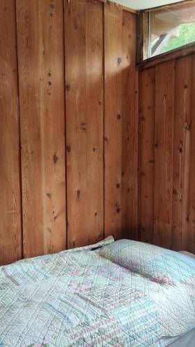 a bedroom with a bed in a wooden wall at Small cottage in Camp, Kerry on the Dingle Way in Camp