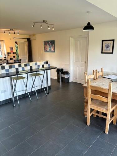 a kitchen with a counter and a table and chairs at The Old Cricket pavilion, Bodiam, East Sussex in Bodiam