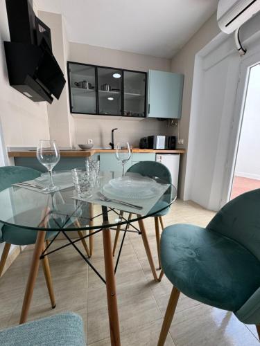 a dining room with a glass table and chairs at Apartamentos Modern Homes in Chiclana de la Frontera