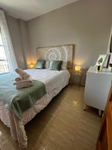 a bedroom with a bed and a dresser at Apartamentos Modern Homes in Chiclana de la Frontera