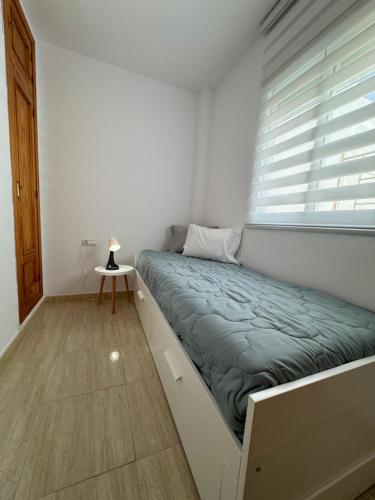 a bed in a room with a window at Apartamentos Modern Homes in Chiclana de la Frontera
