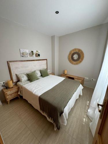 a bedroom with a large bed and a mirror at Apartamentos Modern Homes in Chiclana de la Frontera