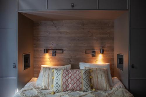 une chambre avec un lit avec une tête de lit en bois dans l'établissement Newly built cabin with sauna, fireplace and amazing view, à Järvsö