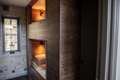 une chambre avec un mur avec deux lits superposés dans l'établissement Newly built cabin with sauna, fireplace and amazing view, à Järvsö