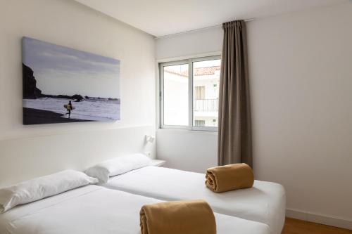 a white bedroom with a bed and a window at Route Active Hotel in Los Realejos