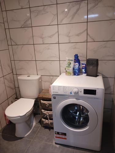 une salle de bain avec machine à laver et toilettes dans l'établissement Joli studio au calme, à Crégandie