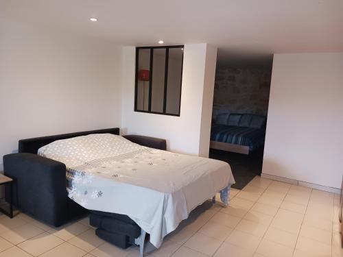 une chambre avec un lit et un canapé dans l'établissement Joli studio au calme, à Crégandie