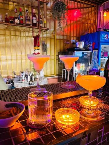 three cocktails sitting on a counter in a bar at Stash in Bangkok
