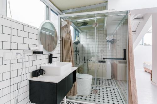 a bathroom with a sink and a mirror and a shower at Shanghai ruochu designer Guesthouse上海若初设计师民宿--近上海浦东国际机场及迪士尼 in Shanghai
