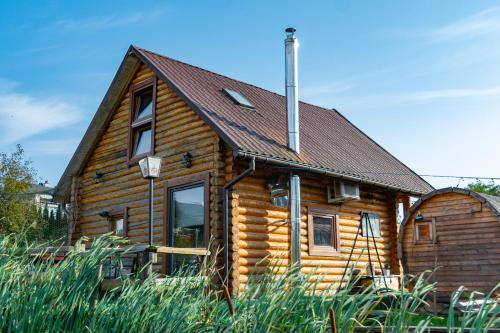 a log cabin with a brown roof at Nad Rozlewiskiem Rzeszów in Rzeszów