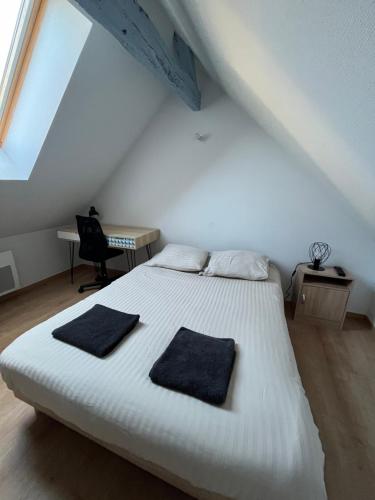 une chambre avec un lit blanc avec deux oreillers dessus dans l'établissement Le Saint-Georges, à Angers